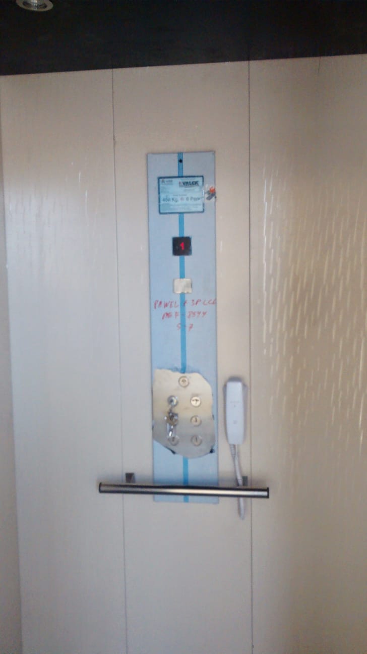 Placa de capacidad VALCK indicando 450 Kg (6 personas) con llave insertada y citófono de emergencia.